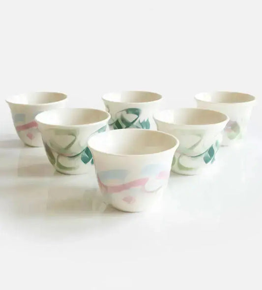 Pastel colored arabic coffee cups featuring Arabic calligraphy done by hand with elegant watercolor brushstrokes