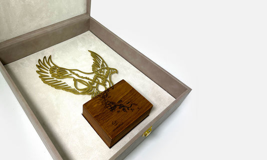 Luxury trophy made of lasercut steel and solid walnut wood featuring a falcon silhouette filled with Arabic calligraphy, designed by Kashida.