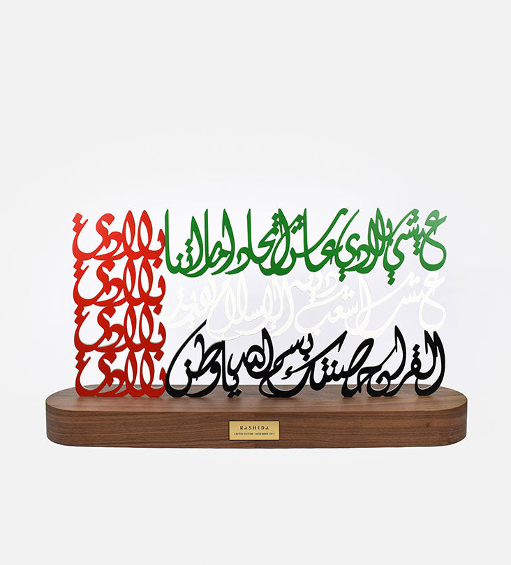 Metal sculpture of the united arab emirates flag featuring the UAE national anthem in Arabic calligraphy