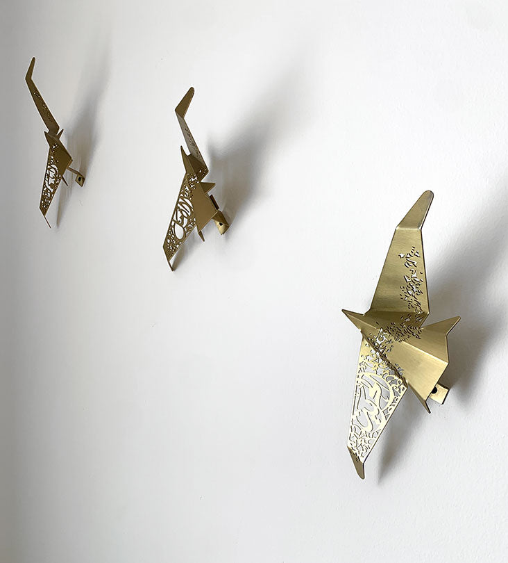 Beautiful brass plated decorative wall hangers shaped like origami birds with modern Arabic calligraphy designed by Kashida