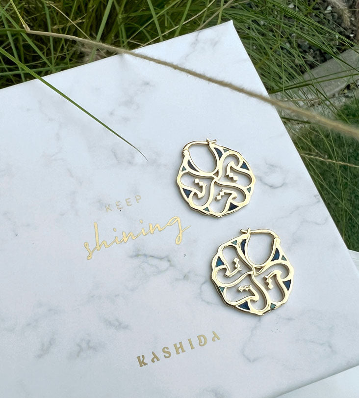 Custom made gold earrings made with Arabic calligraphy letters in arabesque pattern shapes
