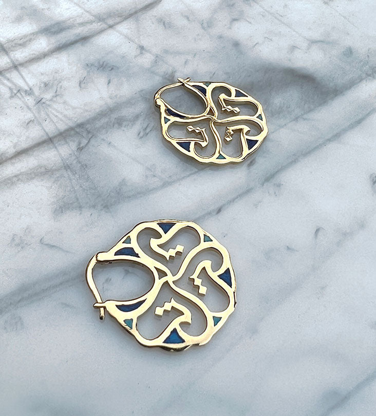 Custom made gold earrings made with Arabic calligraphy letters in arabesque pattern shapes