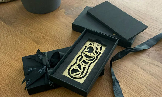 A bookmark written in Arabic calligraffiti script spelling out the words "Knowledge is power".