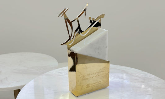 Trophy designed by Kashida with Arabic calligraphy using mirror gold-plated steel and marble