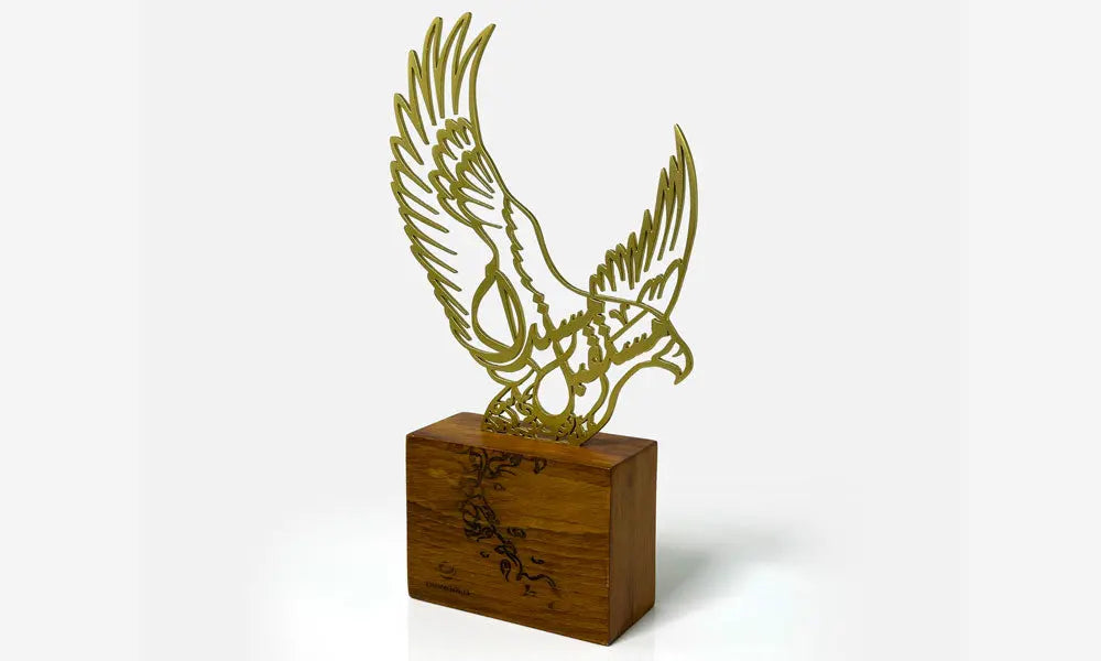 Luxury trophy made of lasercut steel and solid walnut wood featuring a falcon silhouette filled with Arabic calligraphy, designed by Kashida.