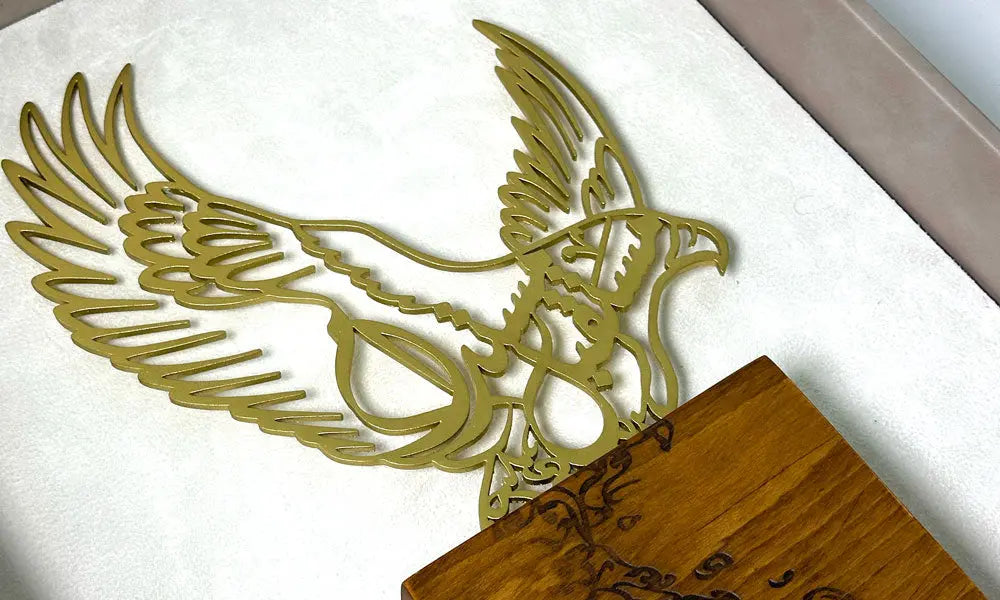 Luxury trophy made of lasercut steel and solid walnut wood featuring a falcon silhouette filled with Arabic calligraphy, designed by Kashida.