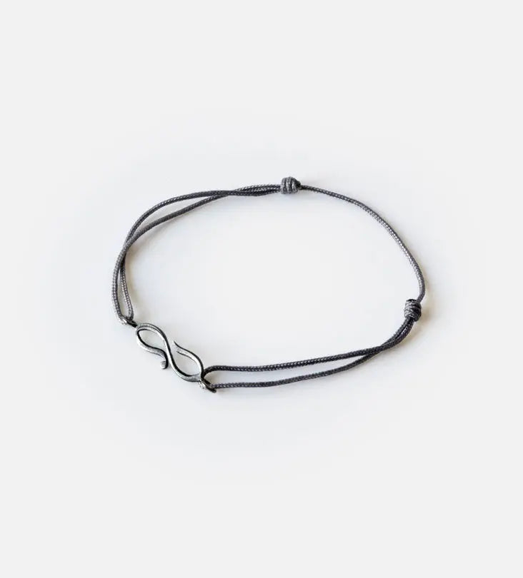 Matching charm bracelets designed by Kashida featuring Arabic calligraphy that spells our love and shaped into an infinity sign
