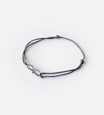 Matching charm bracelets designed by Kashida featuring Arabic calligraphy that spells our love and shaped into an infinity sign
