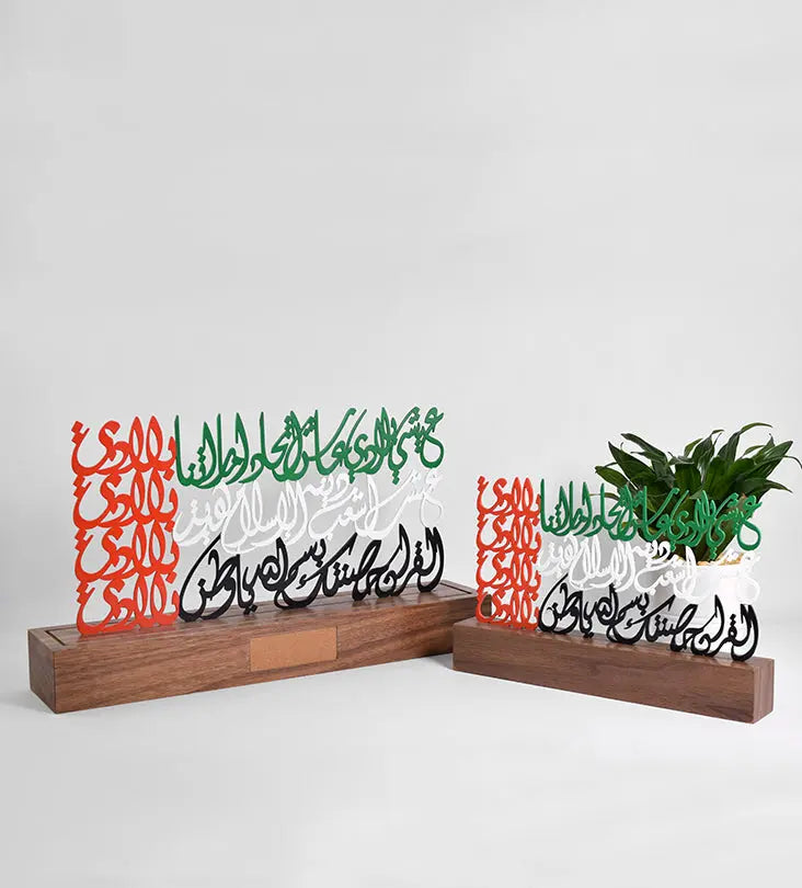 Metal sculpture of the united arab emirates flag featuring the UAE national anthem in Arabic calligraphy