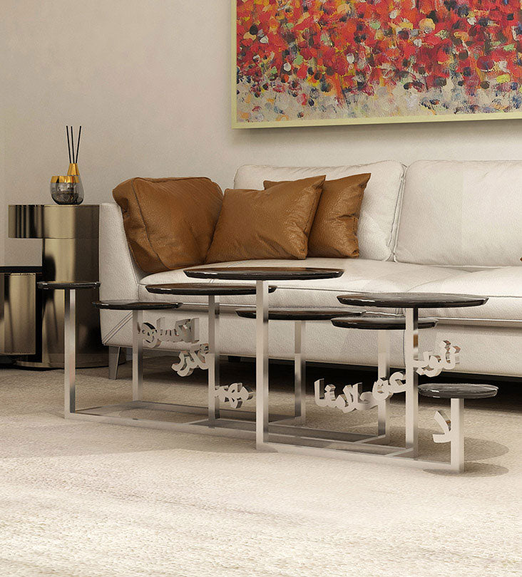 side view of silver and black multi-tiered coffee table with arabic calligraphy steel base and marble table tops