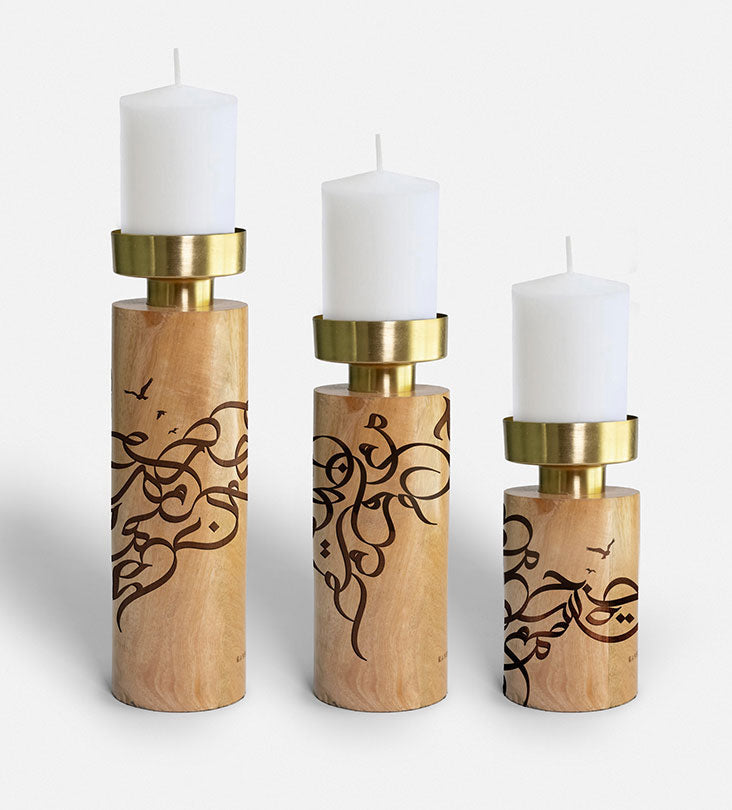 Wooden cylinder candle holders with brass top featuring Arabic graffiti etchings