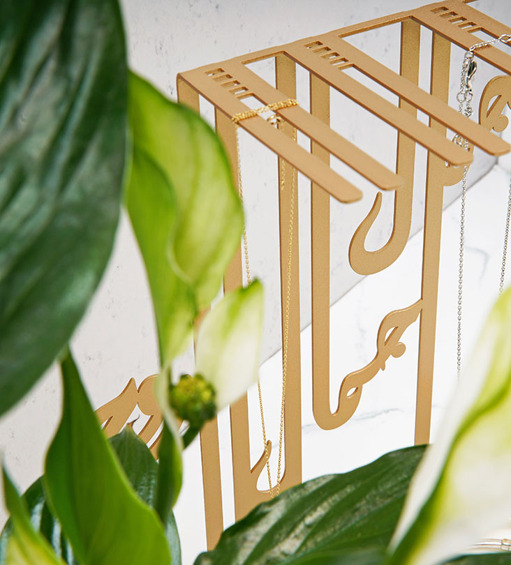 Modern contemporary corian and metal jewelry accent in Arabic calligraphy