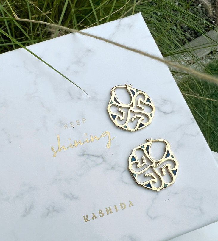 Custom made gold earrings made with Arabic calligraphy letters in arabesque pattern shapes 