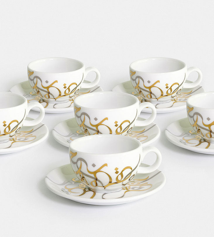Contemporary gold and silver porcelain tea cup and saucer with Arabic graffiti letters