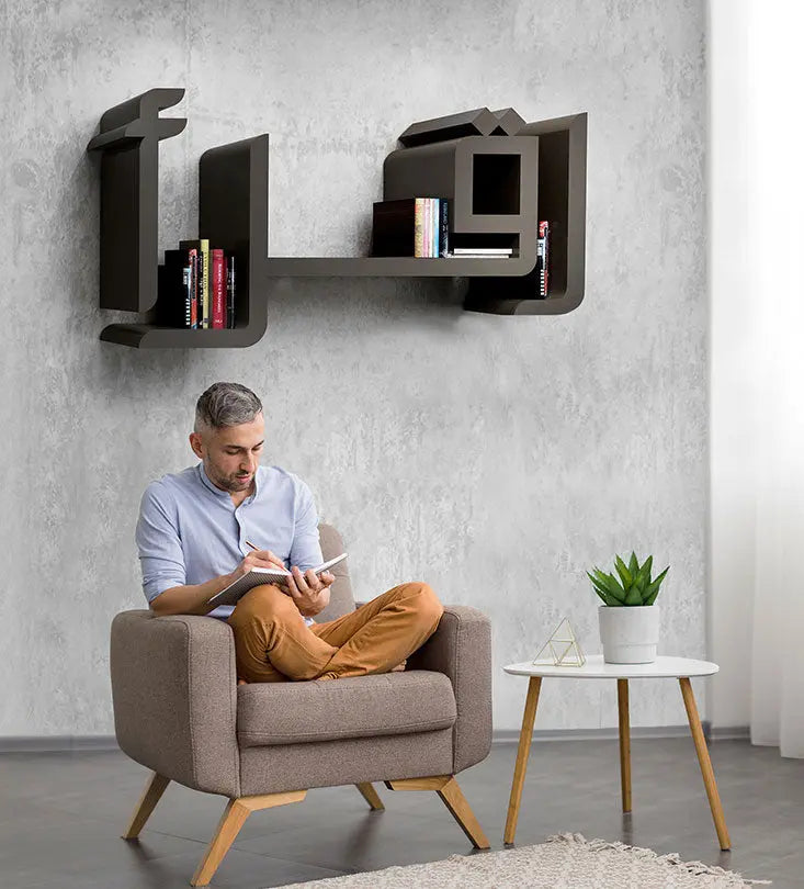 Man enjoying a book beside Kashida Iqra Bookcase translating to read