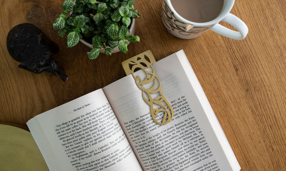 A bookmark written in Arabic calligraffiti script spelling out the words "Knowledge is power".