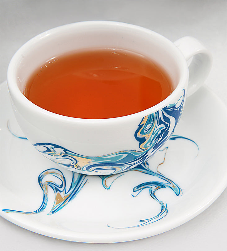 Contemporary porcelain tea cup and saucer with Arabic calligraphy fluid art
