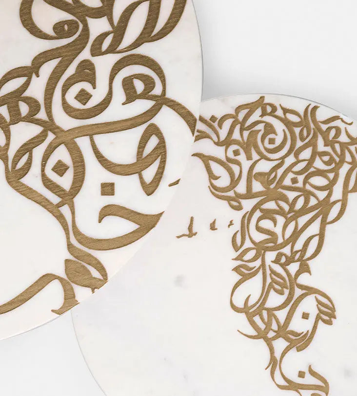 A set of two white marble side tables with contemporary Arabic graffiti etchings and a gold steel base
