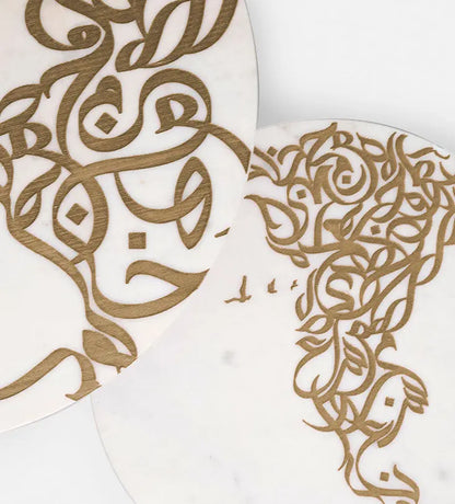 A set of two white marble side tables with contemporary Arabic graffiti etchings and a gold steel base