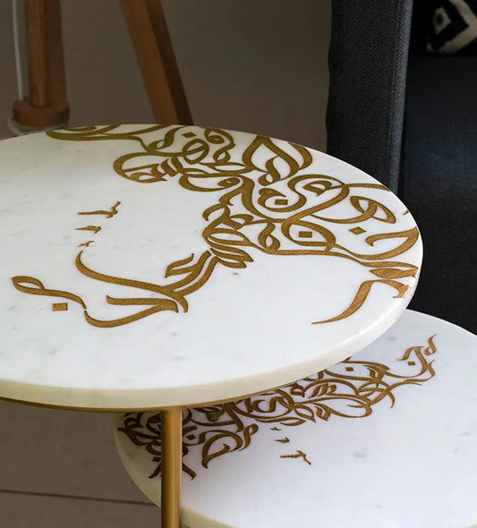 A set of two white marble side tables with contemporary Arabic graffiti etchings and a gold steel base